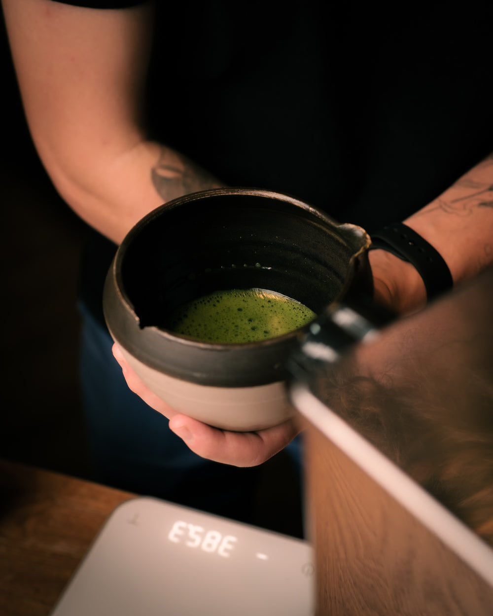 A freshly prepared bowl of matcha held by hand