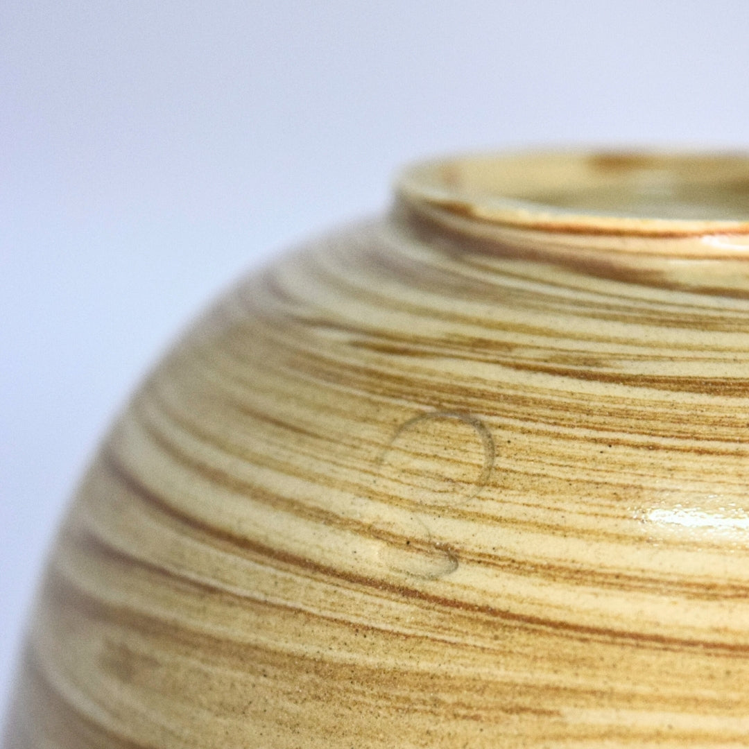 Close-up of handcrafted ceramic matcha bowl with gold glaze and Year of the Horse design, showing glaze texture and rim detail on white background