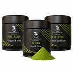 Bonsai Matcha ceremonial trio — Asahi, Zen and Yūhi tins with a mound of bright green matcha powder on white, ceremonial matcha tasting set